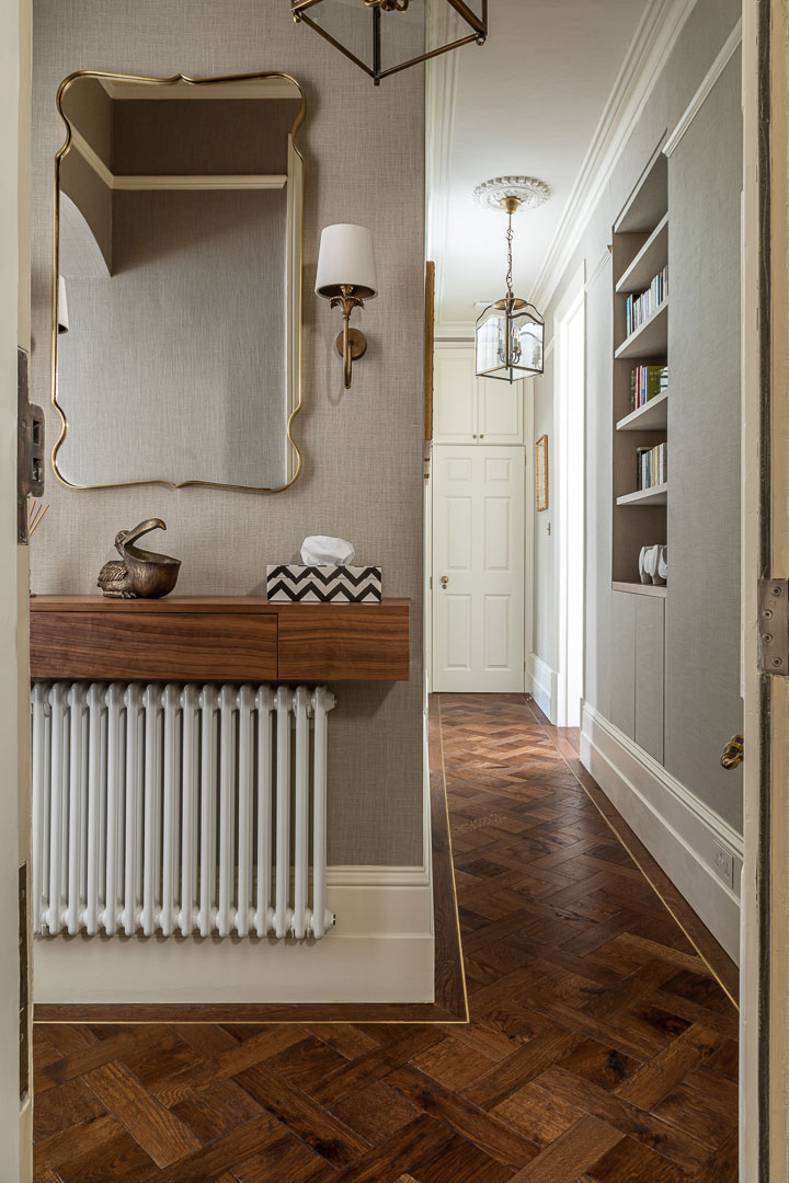 Entrance hallway with walnut console, brass mirror and parquet flooring