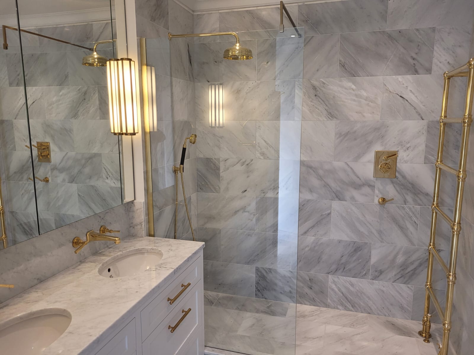 Bathroom in honed marble with antique brass fittings