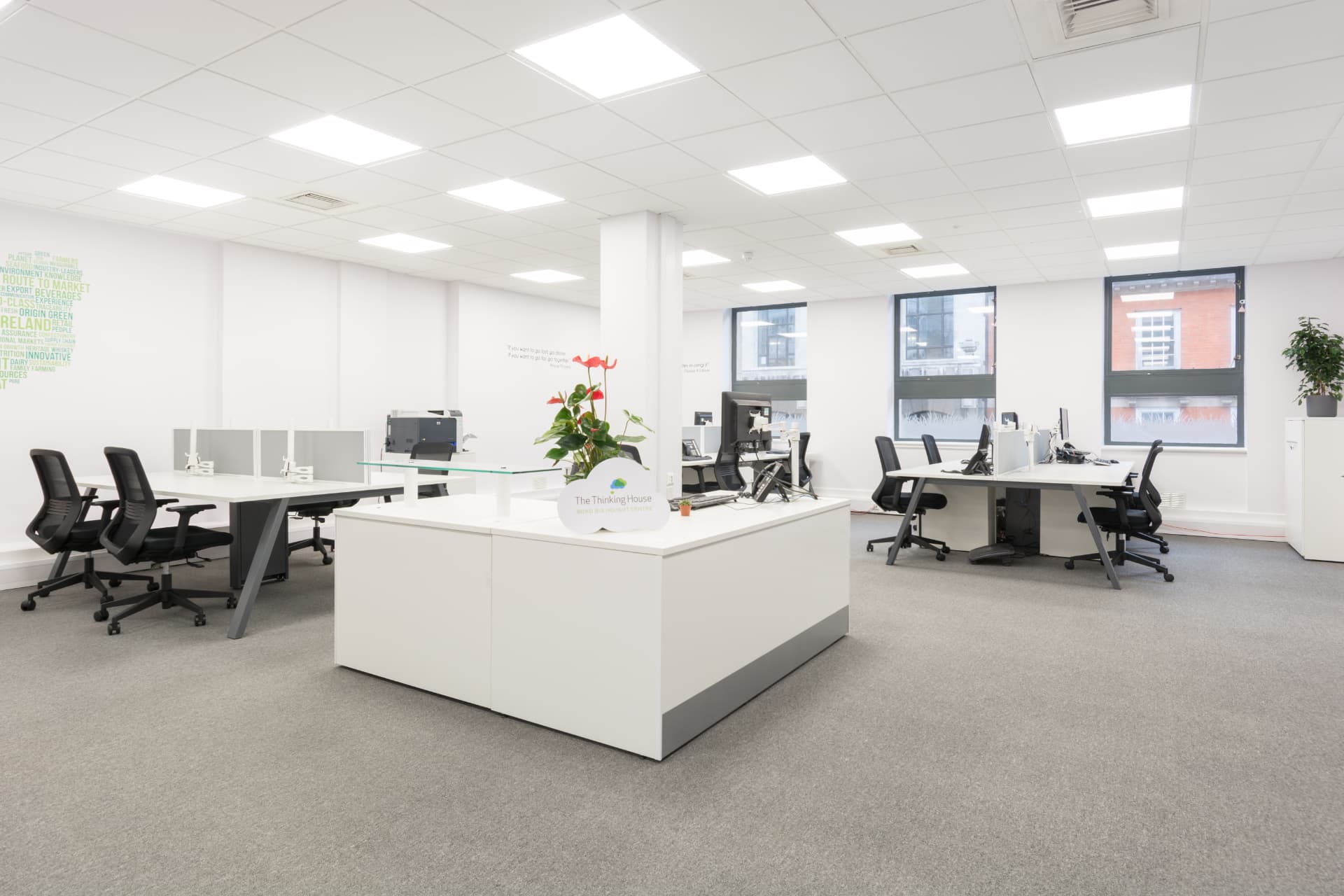 Open-plan office with a long communal table and cloud-patterned glazing
