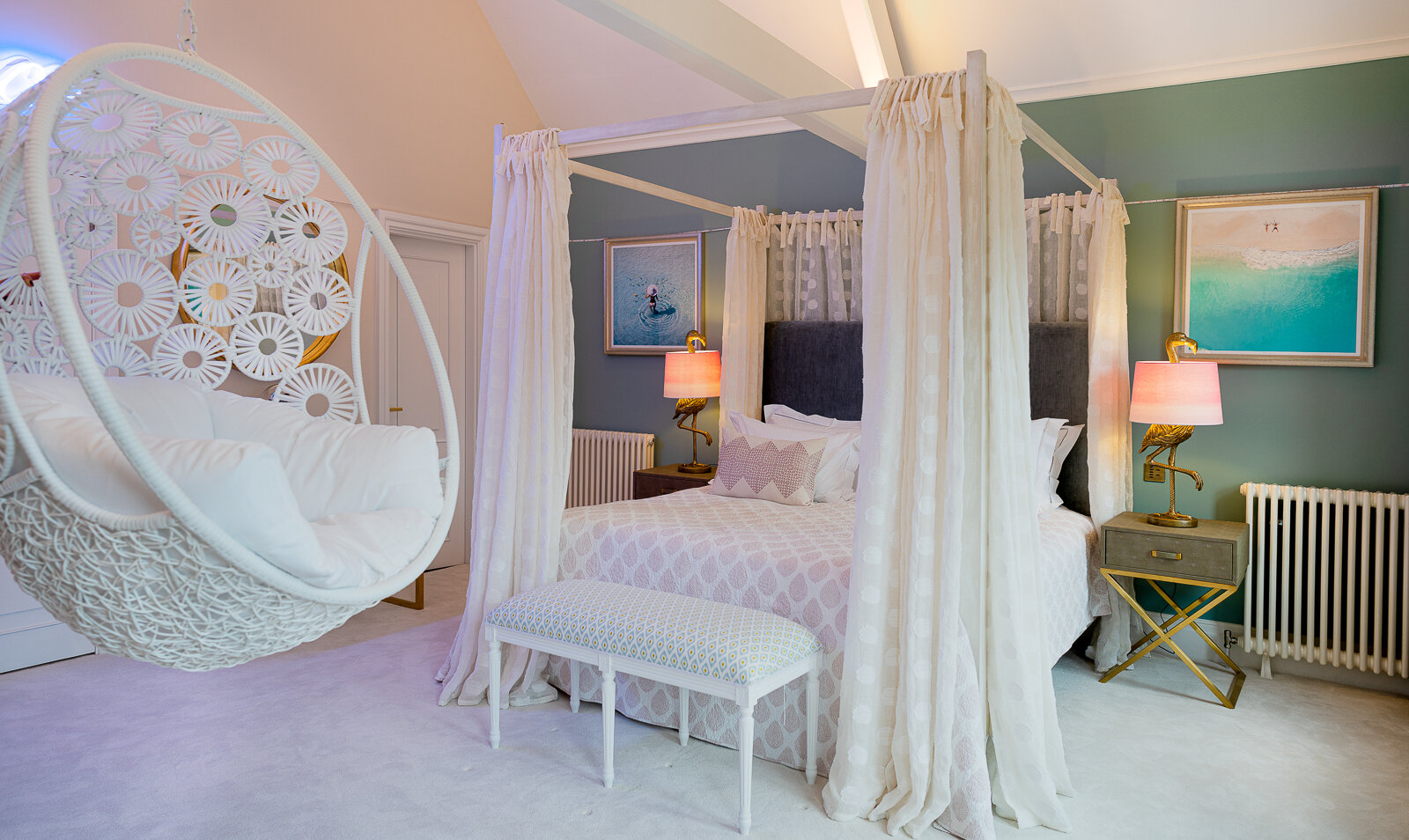 Bedroom with draped four-poster bed and suspended chair