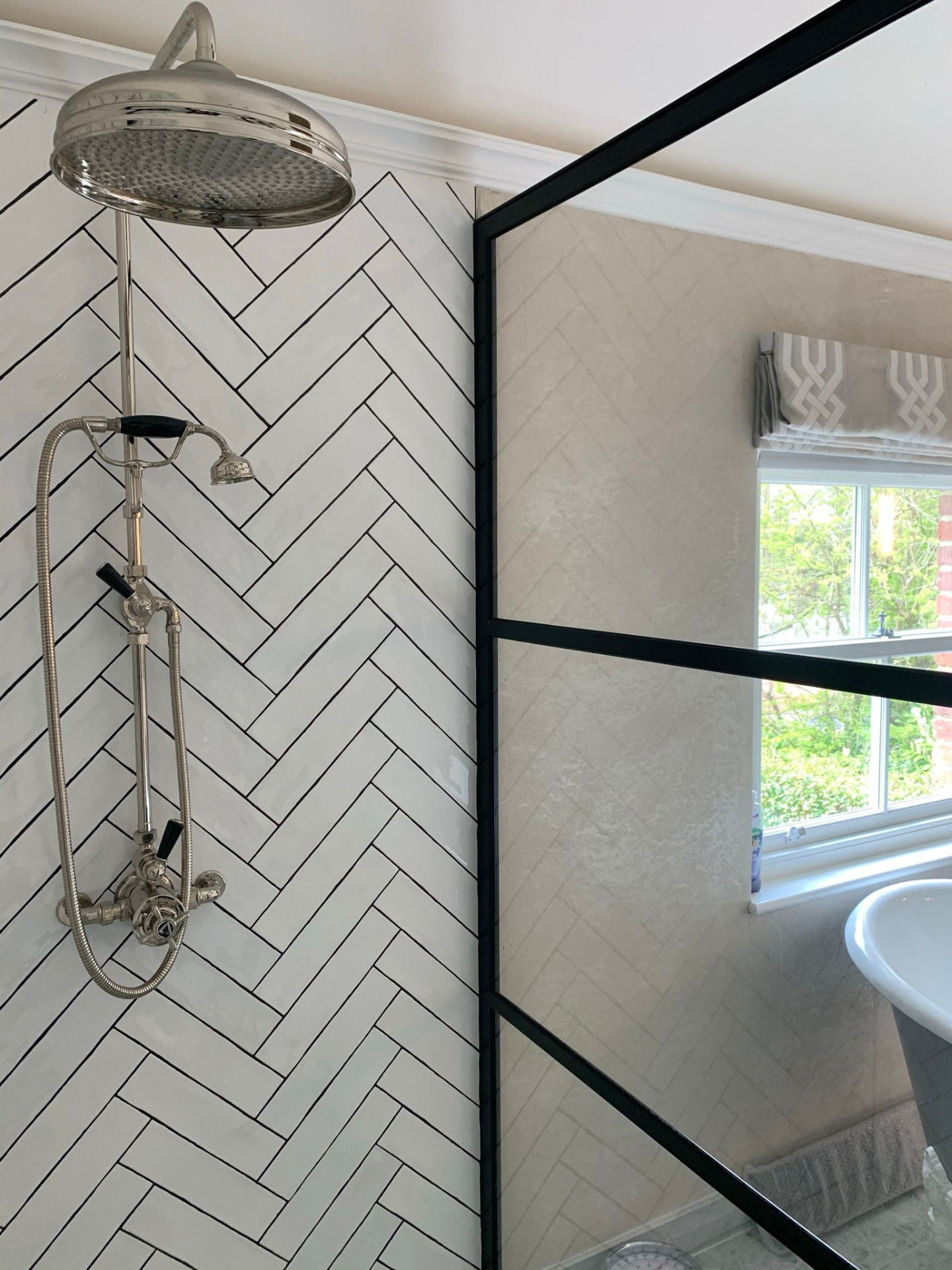 Shower detail with herringbone tiling and chrome fittings