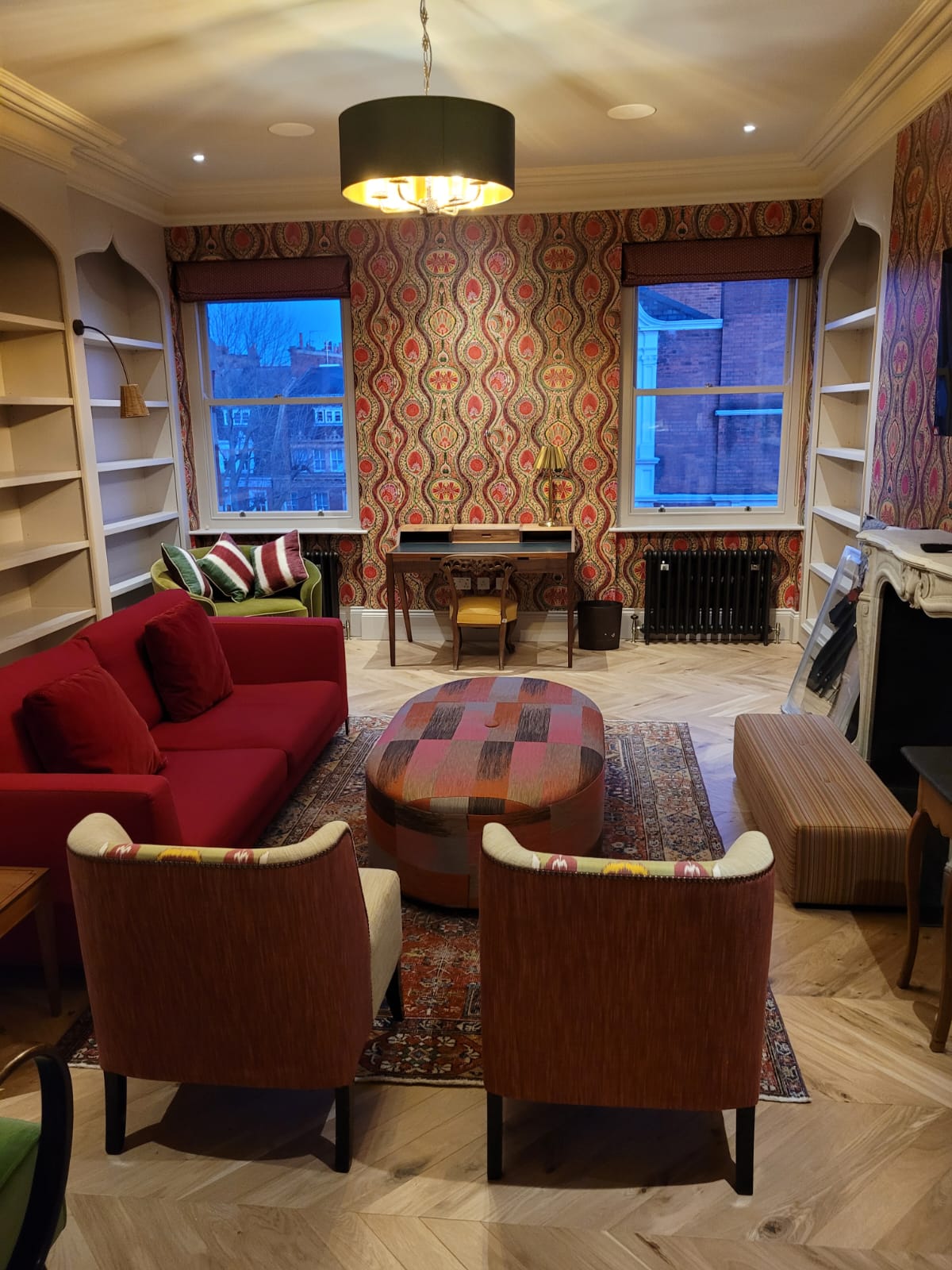 Living room with armchairs, full-length drapes and a chandelier